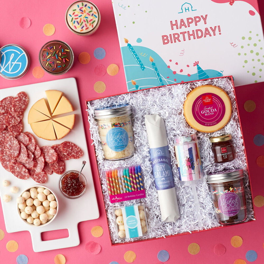 This birthday gift includes cupcakes, Classico Dry Salami, Smoked Gouda Blend, Strawberry Fig Jam, and Confetti Cake Bites, birthday candles, and a confetti popper.